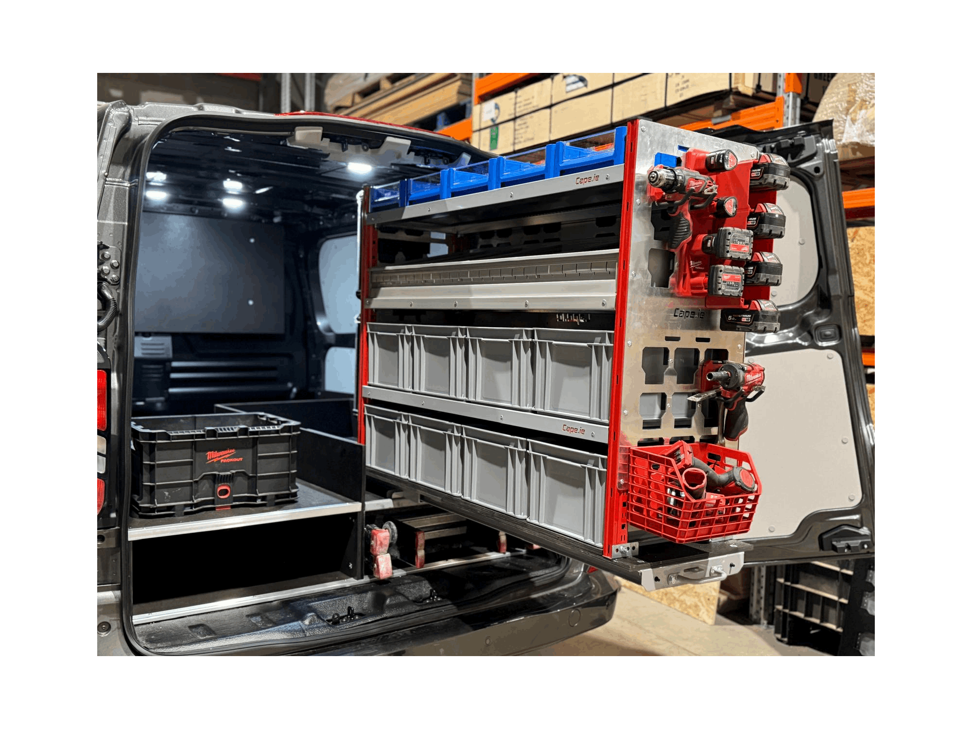 Picture of a Milwaukee Packout Pull Out Shelving Unit in a Van with Selections of Grey and Blue Boxes with a Bin Kit with Milwaukee Packout Accessories clipped onto the Milwaukee Packout Gables