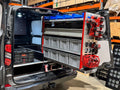 Picture of a Milwaukee Packout Pull Out Shelving Unit in a Van with Selections of Blue Shelf Bins and Grey Euro Boxes, a Bin Kit and Milwaukee Packout Accessories Clipped onto the Milwaukee Packout Gable.