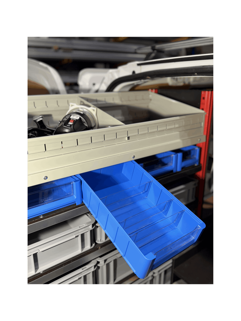 A Blue Shelf Bin being Displayed on a Pull Out Shelving Unit in a Van