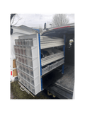A Stack of MB Boxes on the Back of a Pull Out Shelving Unit with a Selection of Grey Euro Boxes and 2 Bin Kits in a Van