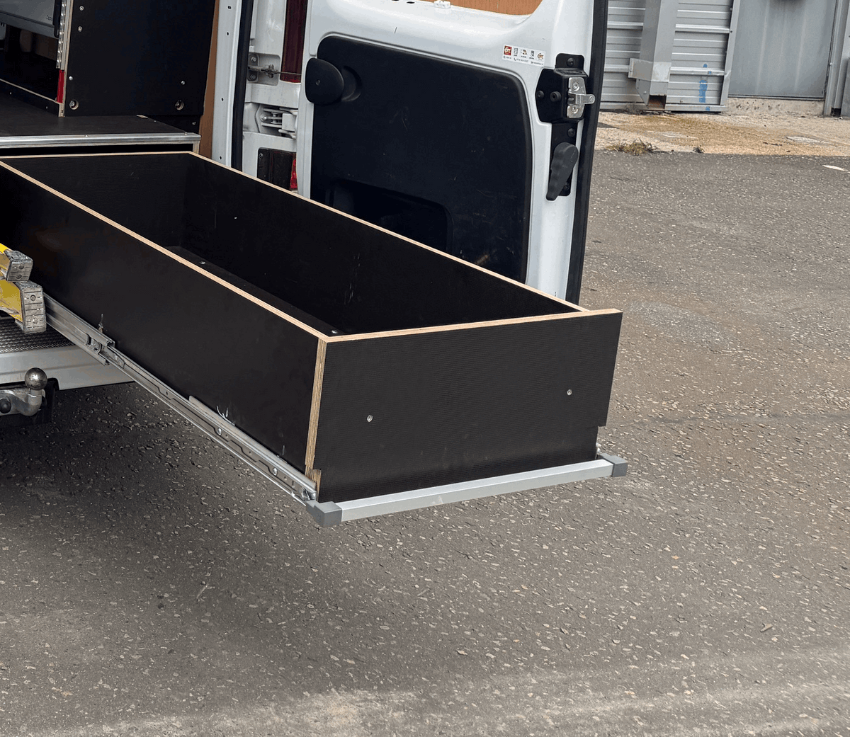 A False Floor Drawer Opened out from the Back Door of a Van